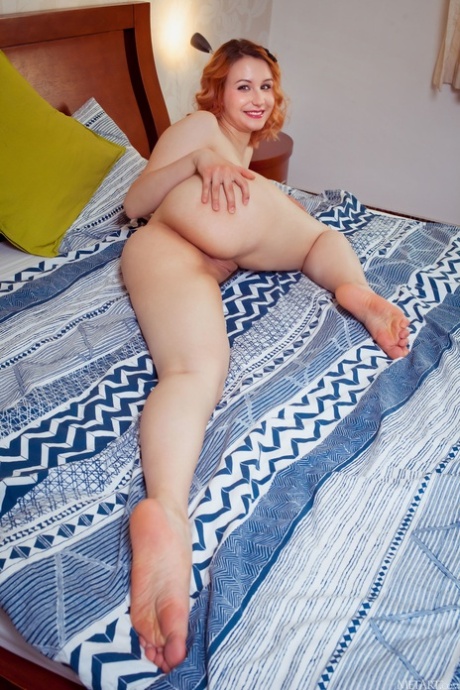 Beautiful redhead Spice shows her big ass & her trimmed pussy on her bed